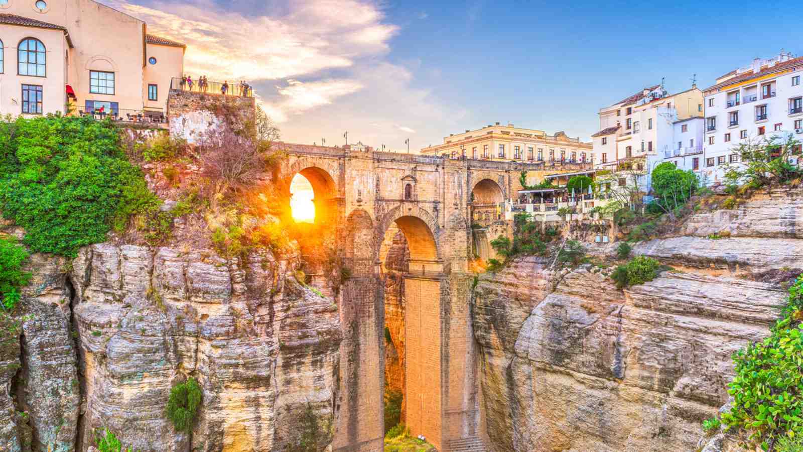 A landscape shot of a village and bridge built on the top of very steep cliffs.