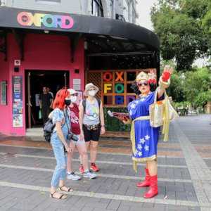 A drag queen in a Wonder Woman outfit showing tourists gay hotspots on Oxford Street in Sydney, Australia.