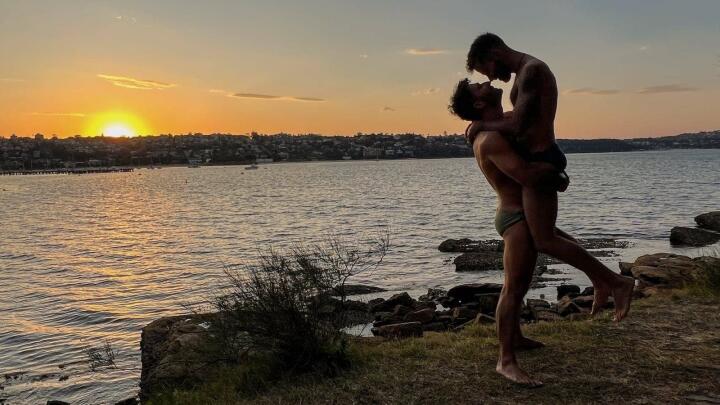 Gay couple at sunset on Cobblers gay beach in Sydney.