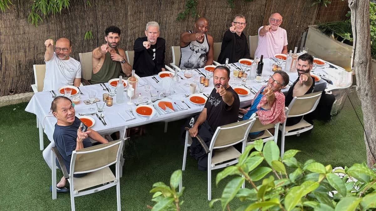 Gay group point and pout at dinner in French villa.