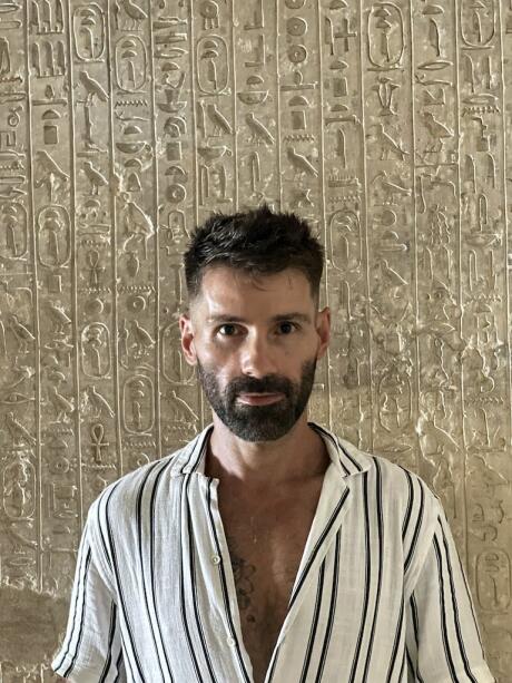 Seby in front of a hieroglyphics wall found in a pyramid in Giza, Egypt.