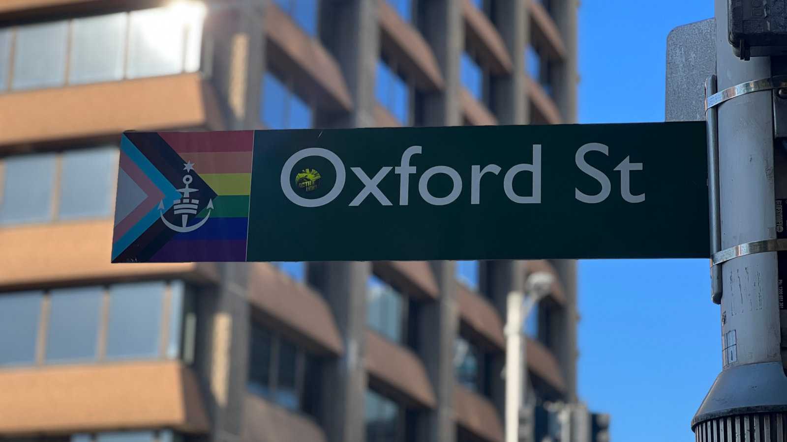 A street sign for Oxford Street in Sydney with a small LGBTQ+ flag to show it's the main 'gay' street in the city.