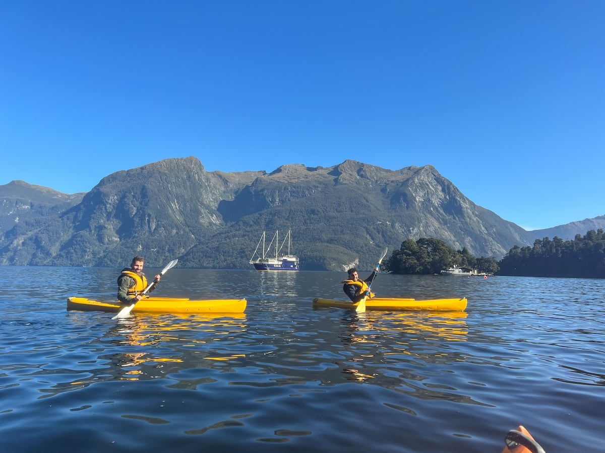 Gay couple kayaking in Doubtful Sound in the Fiordland of New Zealand