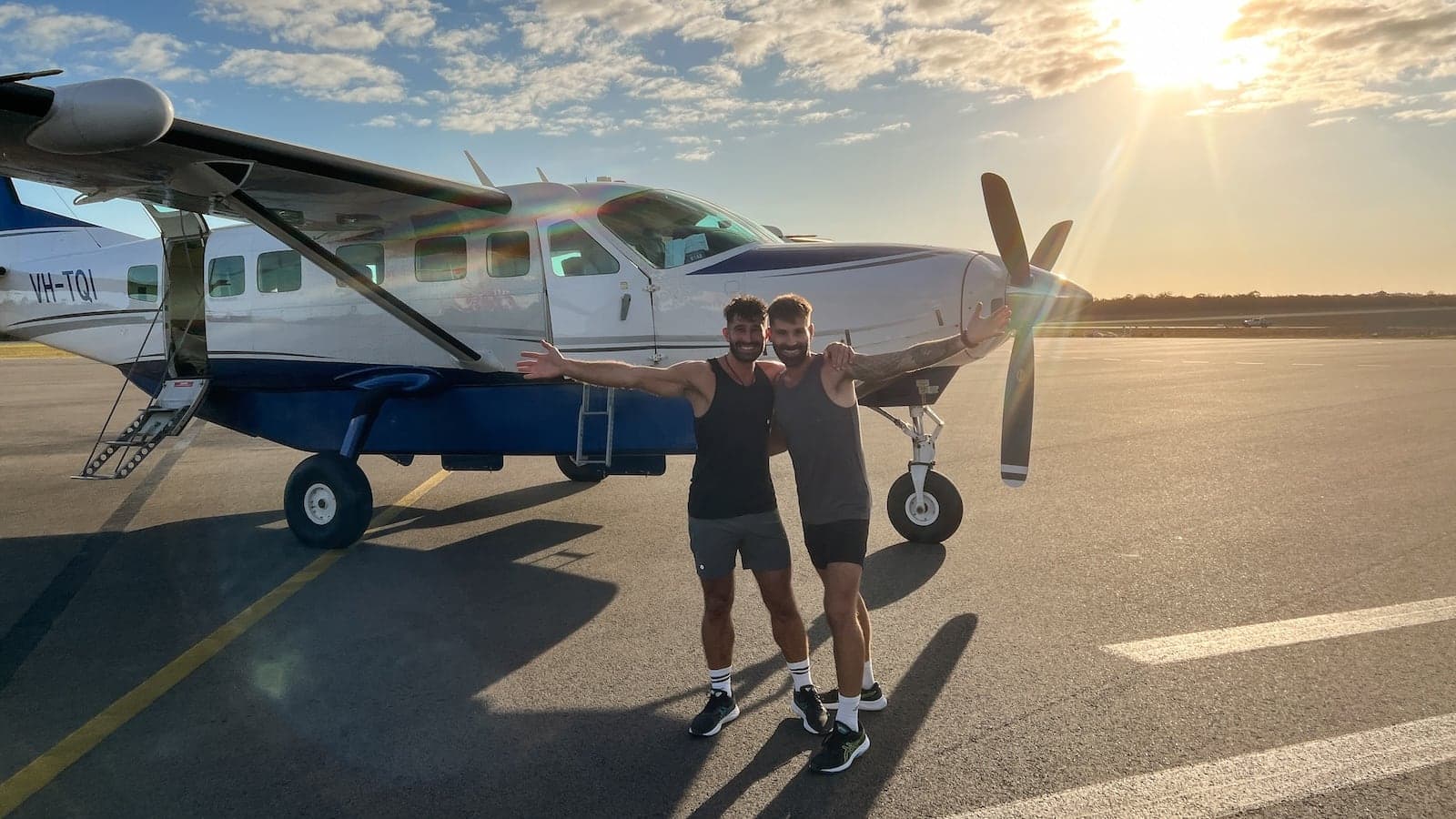 Gay couple in front of small plane bound for Lady Elliot Island.