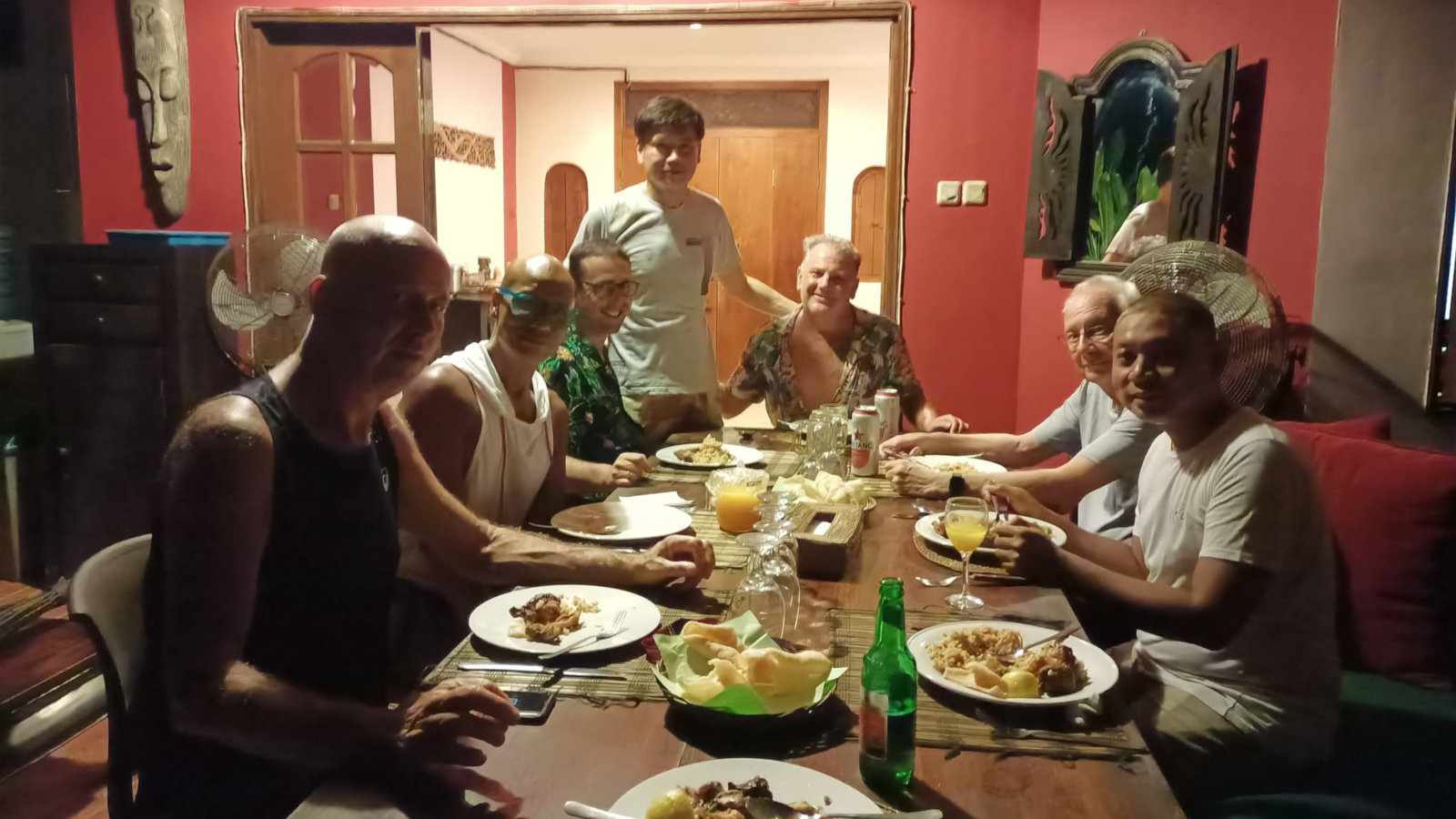 A group of men gathered around a table for a meal together.