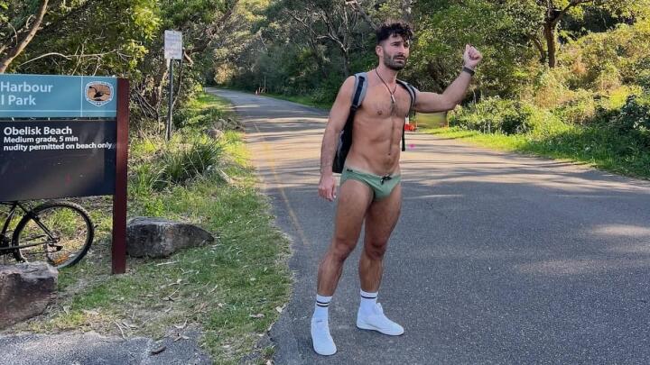Stefan hitchhiking in Speedos at the Obelisk gay beach in Sydney, Australia.