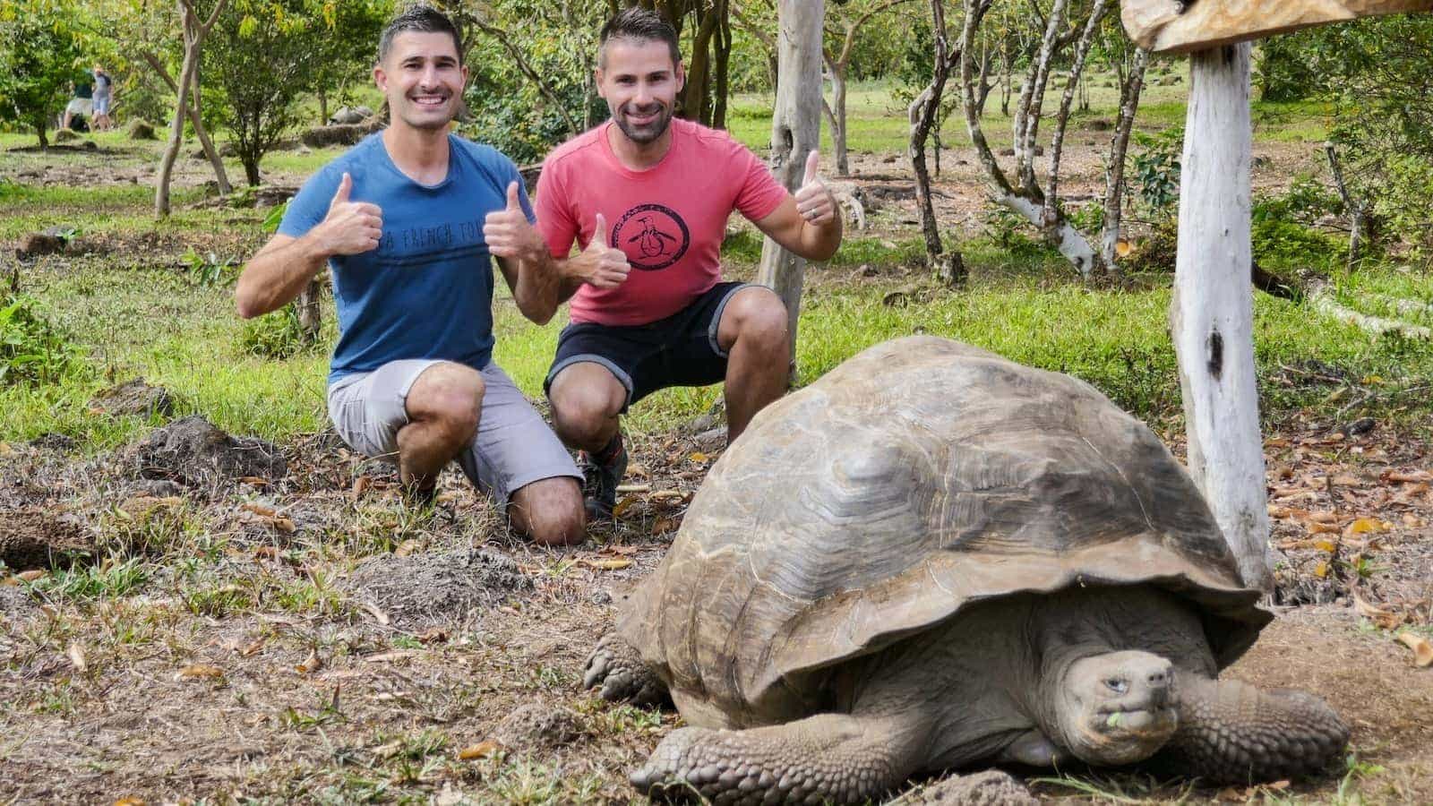 Gay couple with giant Galapagos Tortoise on Santa Cruz Island.