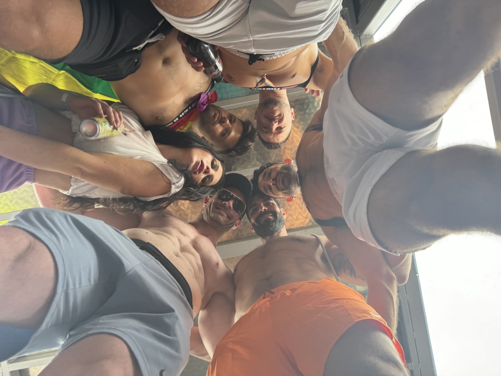 Group of gay guys looking down at the camera at Berlin Pride.