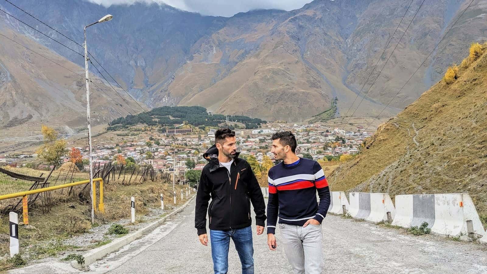 Gay couple hiking in the Kazbegi Mountains in Georgia.