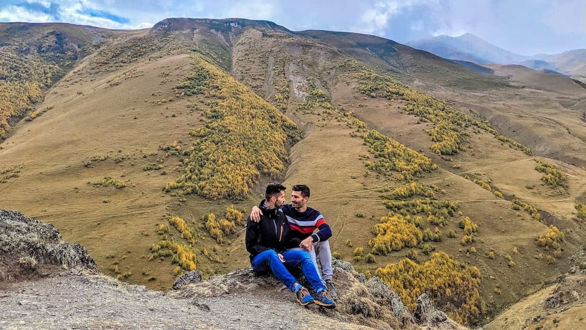 Gay couple resting in the Kazbegi mountains in Georgia.