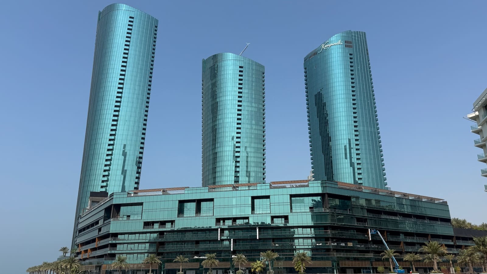 Three blue-green skyscrapers against a blue sky.