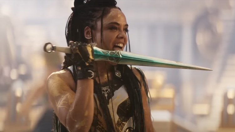 A screenshot of Valkyrie licking her knife from the film Thor Love and Thunder.