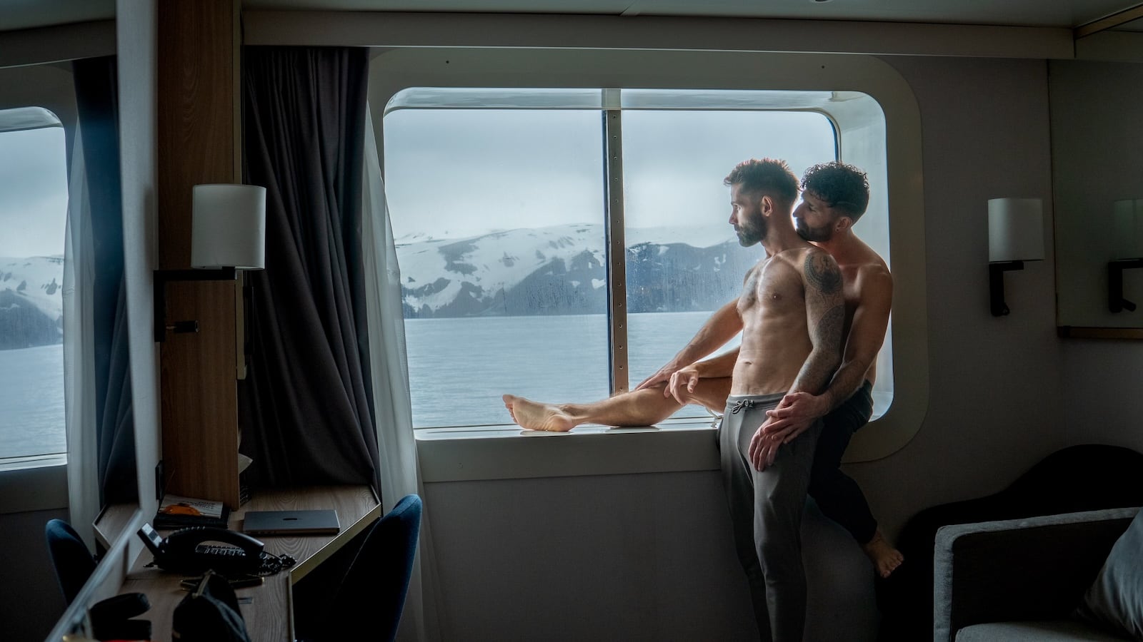 Gay couple embrace on Antarctica cruise ship.