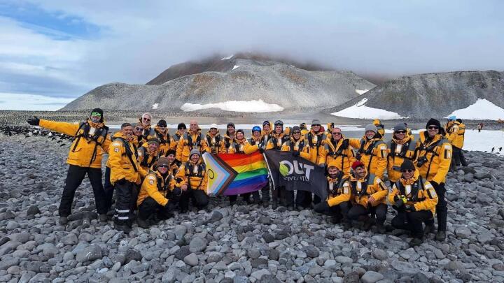 Gay Out Adventures group in Antarctica with rainbow flag.