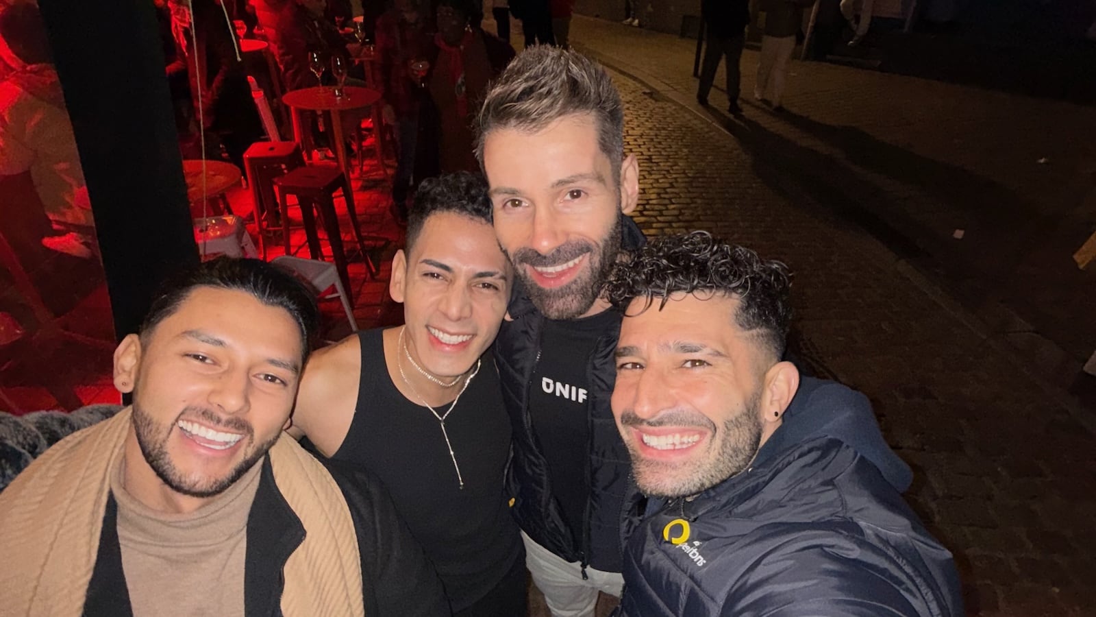 Seby and Stefan posing with two other guys on a street at night.