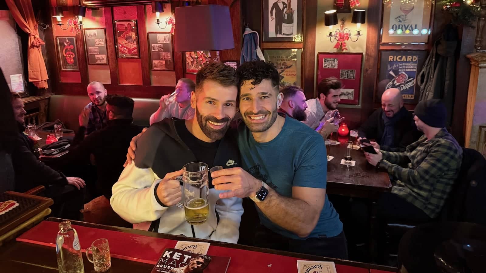 Seby and Stefan posing with drinks at a bar together.