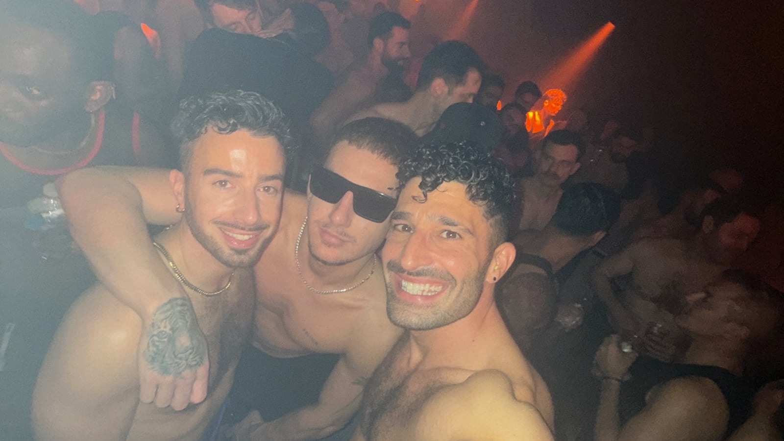 Stefan and two friends posing topless in a club.