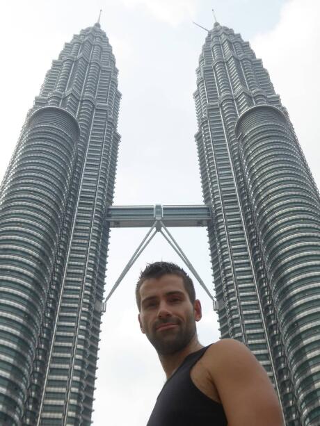 A low angle shot of Seby's head and shoulders in front of two tall linked skyscrapers.