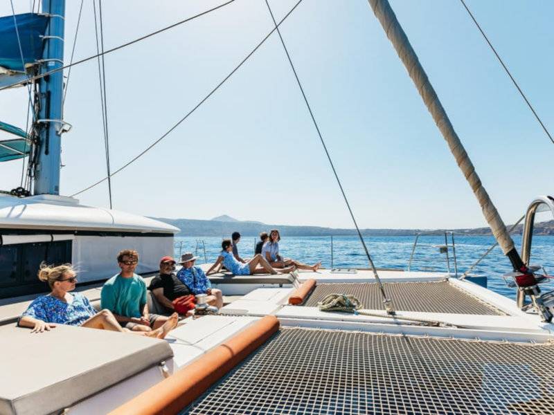 People relaxing on a luxury catamaran on the sea in the sun.