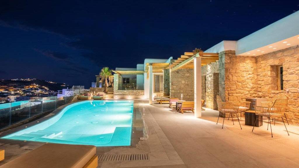 A night-time view of a lit up infinity pool.