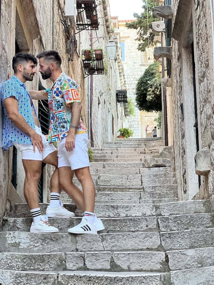 Gay couple embrace in the stairs of Dubrovnic.
