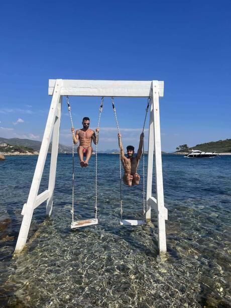 Gay couple on swing at Korcula island in Croatia.