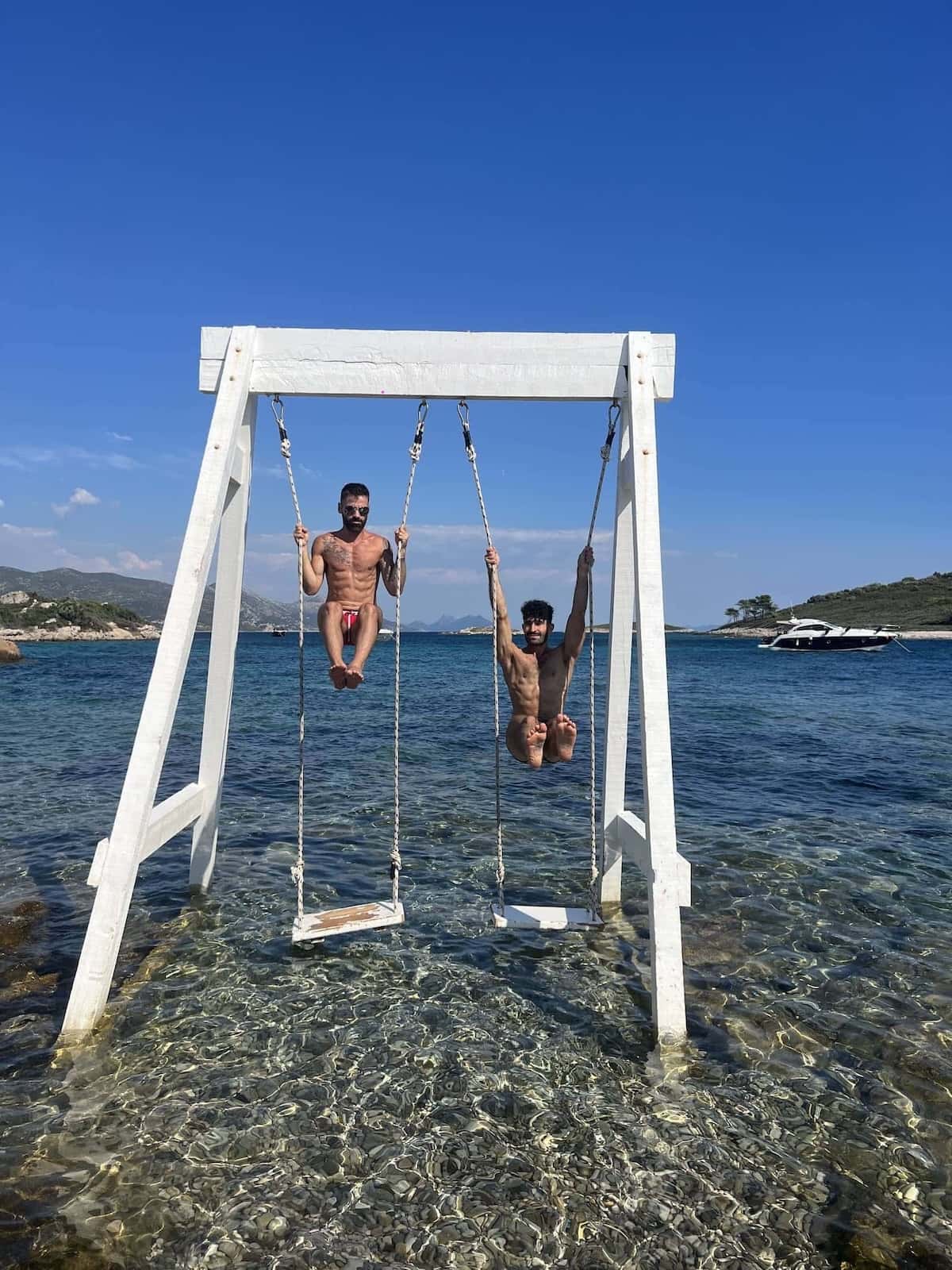 Gay couple on swing at Korcula island in Croatia.