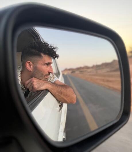 Stefan reflection in a car door mirror in Al Ula, Saudi Arabia.