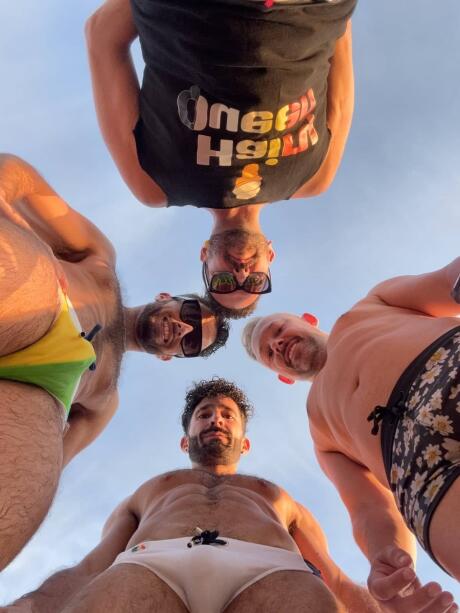 Hot gay guys looking down at the camera at Vancouver Kitsilano Beach.