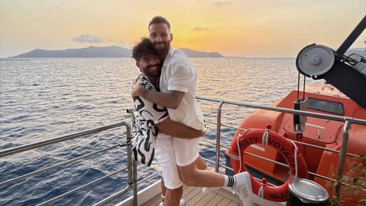 Stefan lifting Seb during our gay couple gay cruise in Greece at sunset.