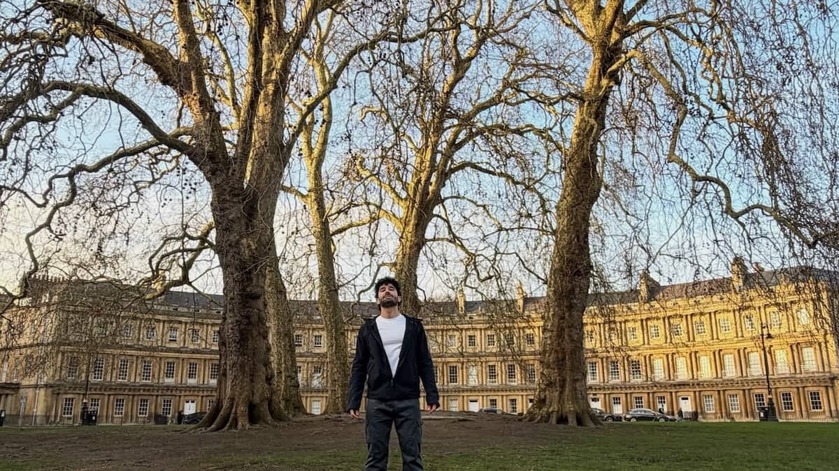 Stefan posing at The Circus in Bath with trees.