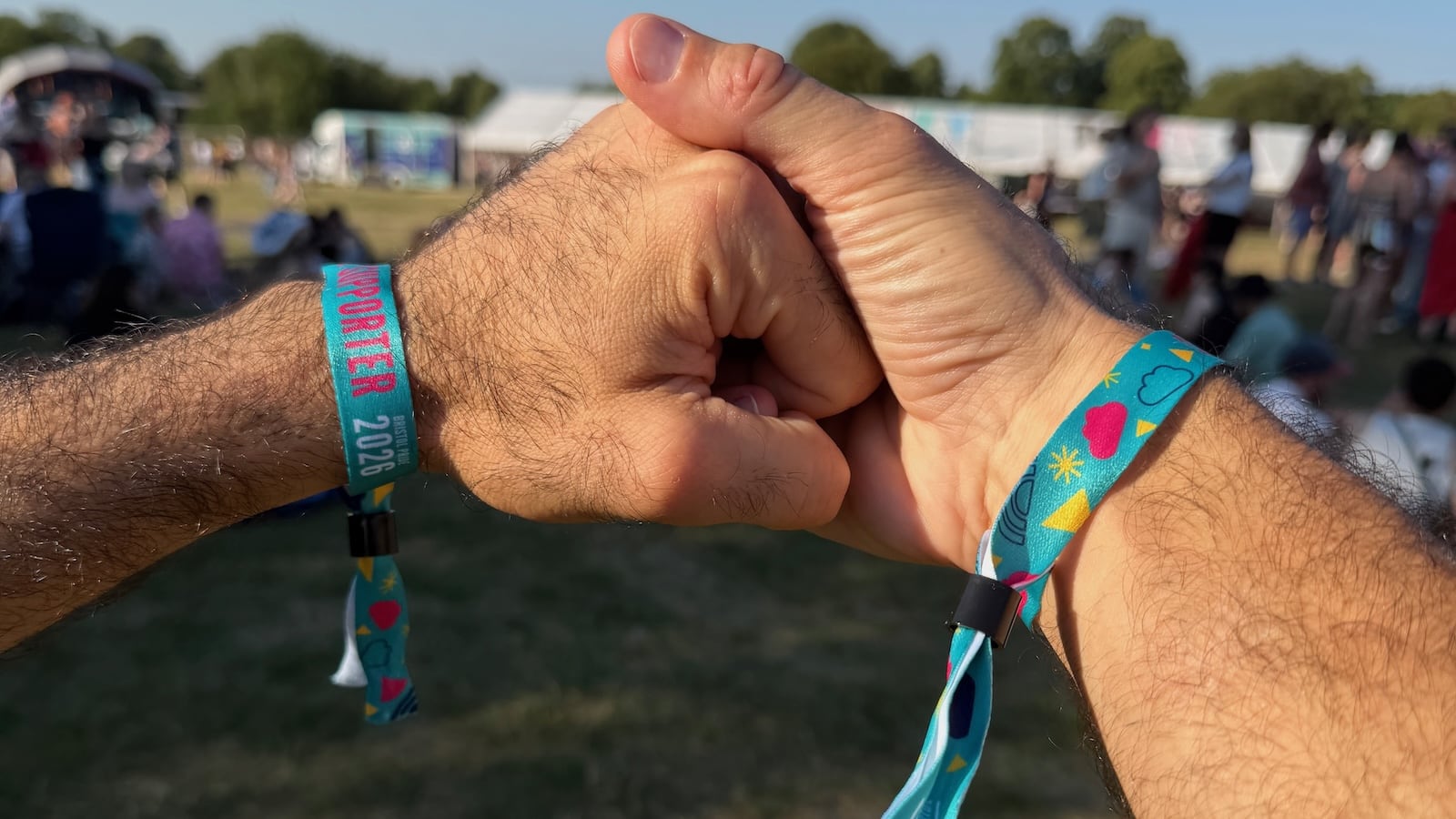 Two men holding hands with Bristol Pride wristband.