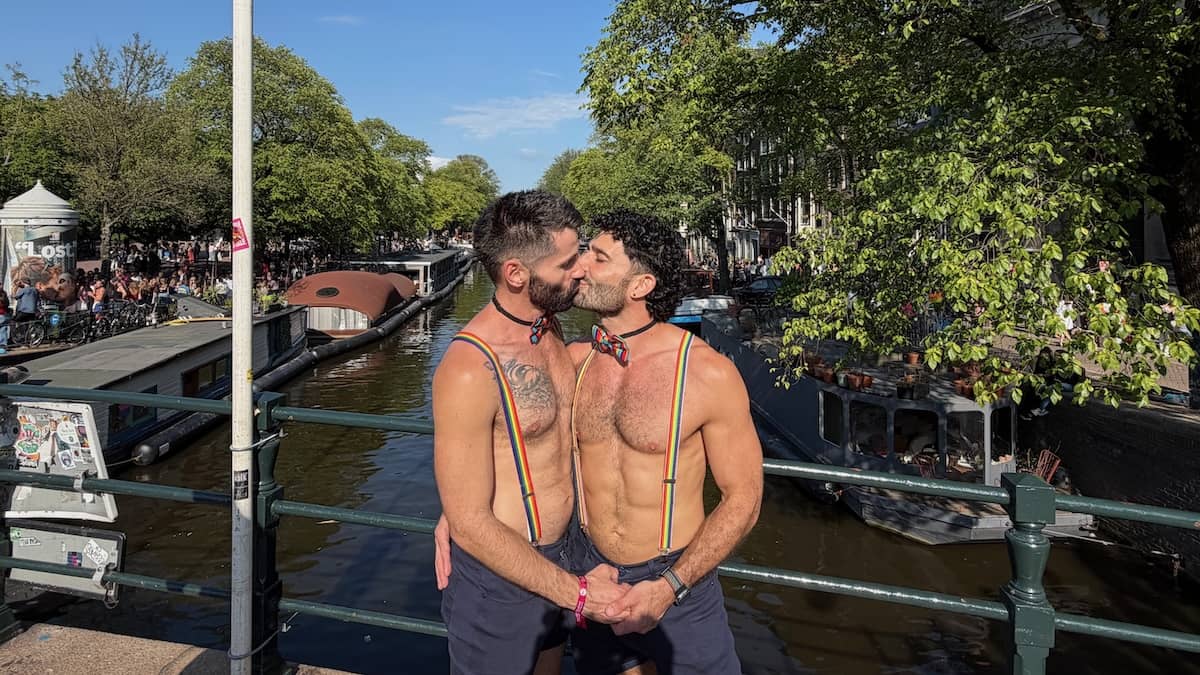Gay couple kissing in Amsterdam canals during WorldPride.